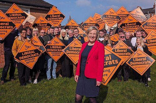 Lisa Smart with Lib Dem group and diamonds behind her