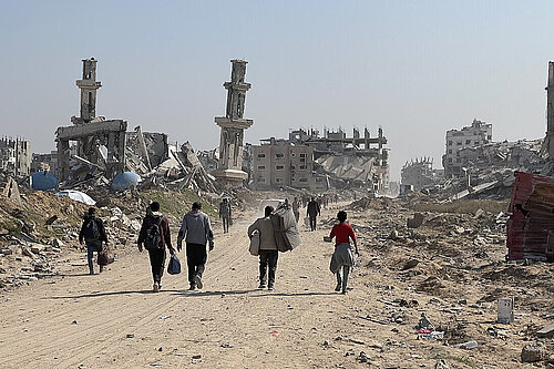 Group of people walking down destroyed areas in Gaza