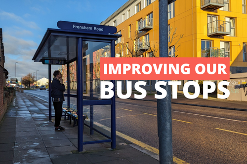 A man stood at a bus stop with the words 'Improving Our Bus Stops'