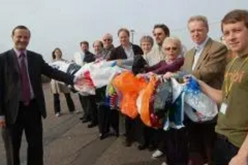Stephen Robinson, Steve Webb and other Liberal Democrats holding a line of plastic bags