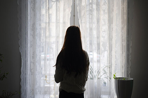 A woman looking out a window.