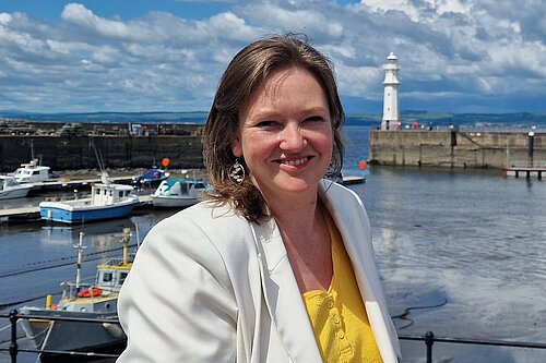 Sanne standing at Newhaven Harbour on a sunny day