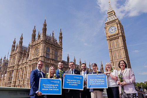 Tom Gordon stood in front of the Houses of Parliament with Yorkshire Cancer Research placards and some of the Yorkshire Cancer Research team
