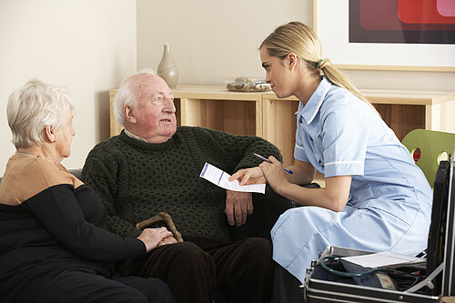 A nurse treating two old people.
