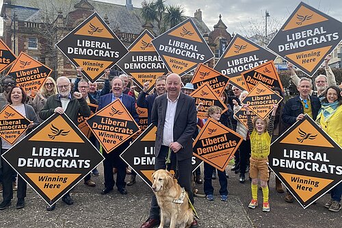 Steve with a big group of Lib Dem supporters and Lib Dem signs. 