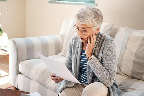 A lady looking at her bills.