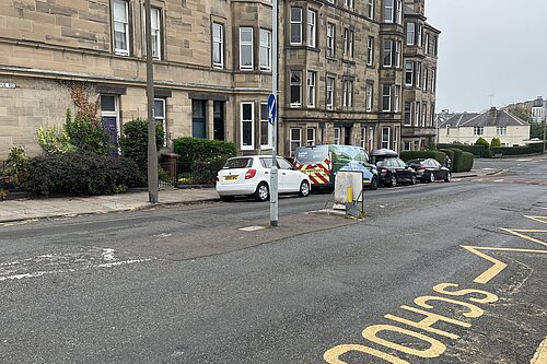 A road with tenements in the background.