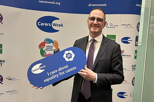 Ian holding a sign saying "equality for carers"