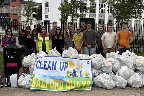 Litter pickers with all the bags at the end of the litter pick behind the clean up salford quays banner