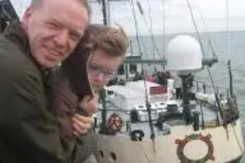 Stephen Robinson with his son at the Greenpeace ship 'Rainbow Warrior'