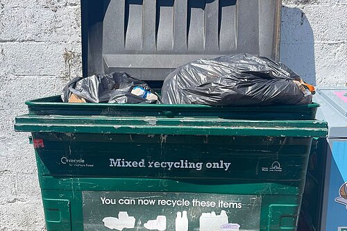 Rubbish dumped in communal recycling bins