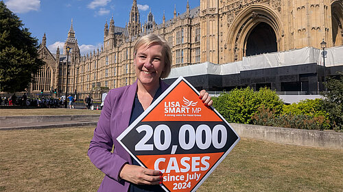 Lisa Smart MP with a 20,000 cases poster