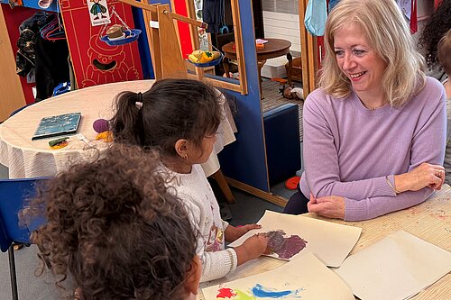 Liz Jarvis MP sat with 2 primary school students in a school