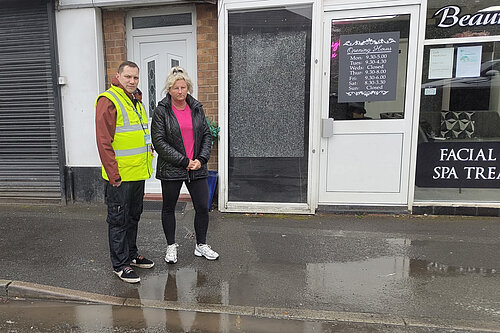 Councillor Louie Hamblett and Debbie Morris standing beside the flooding