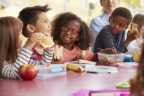 Children eating a packed lunch at a table