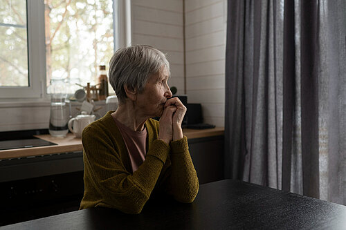 An elderly lady looking off into the distance.