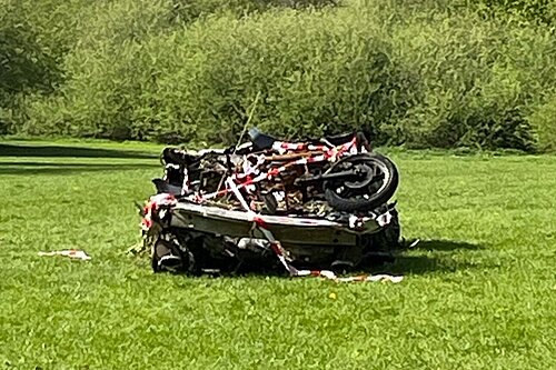 Burnt out car in field