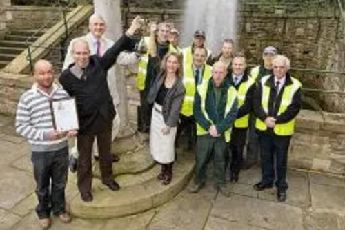 Rochdale Council’s Dave Woolrich, Andrew Whitehead, and Councillors William and Wera Hobhouse hold the North West In Bloom Heritage Award trophy aloft at Packer Spout.