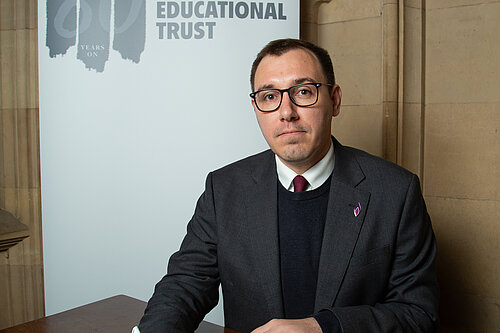 Tom Gordon sat at a table as he signs the Holocaust Educational's Trust Book of Commitment