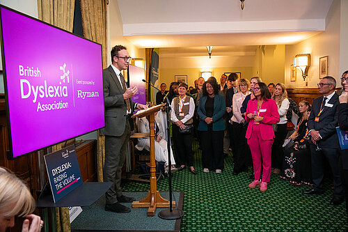 Adam Dance MP speaks at a British Dyslexia Association event in Parliament, addressing a room full of attendees gathered to support greater awareness and action on dyslexia.