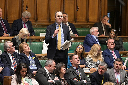 Richard Foord standing in Parliament surrounded by other MPs