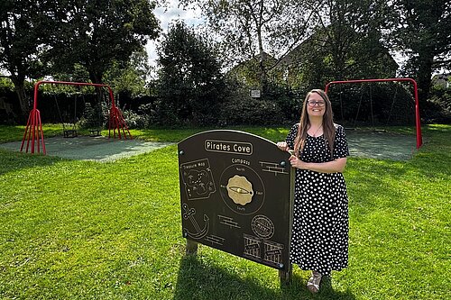 Cllr Sarah Syrda stands by an activity board in the play park