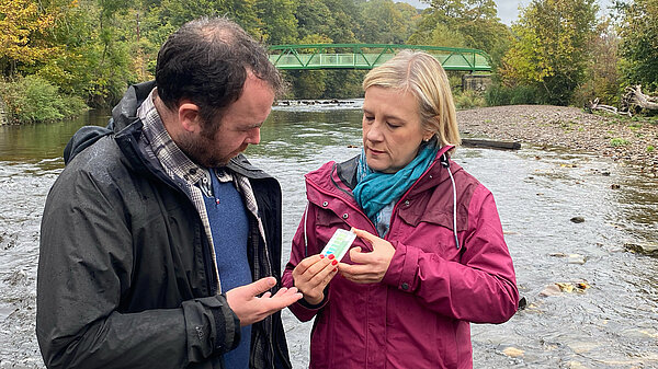 Mark Roberts and Lisa Smart conducting water tests in a river